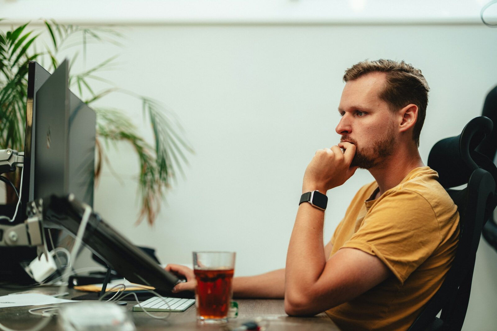 a man sitting at a desk with a drink next to him