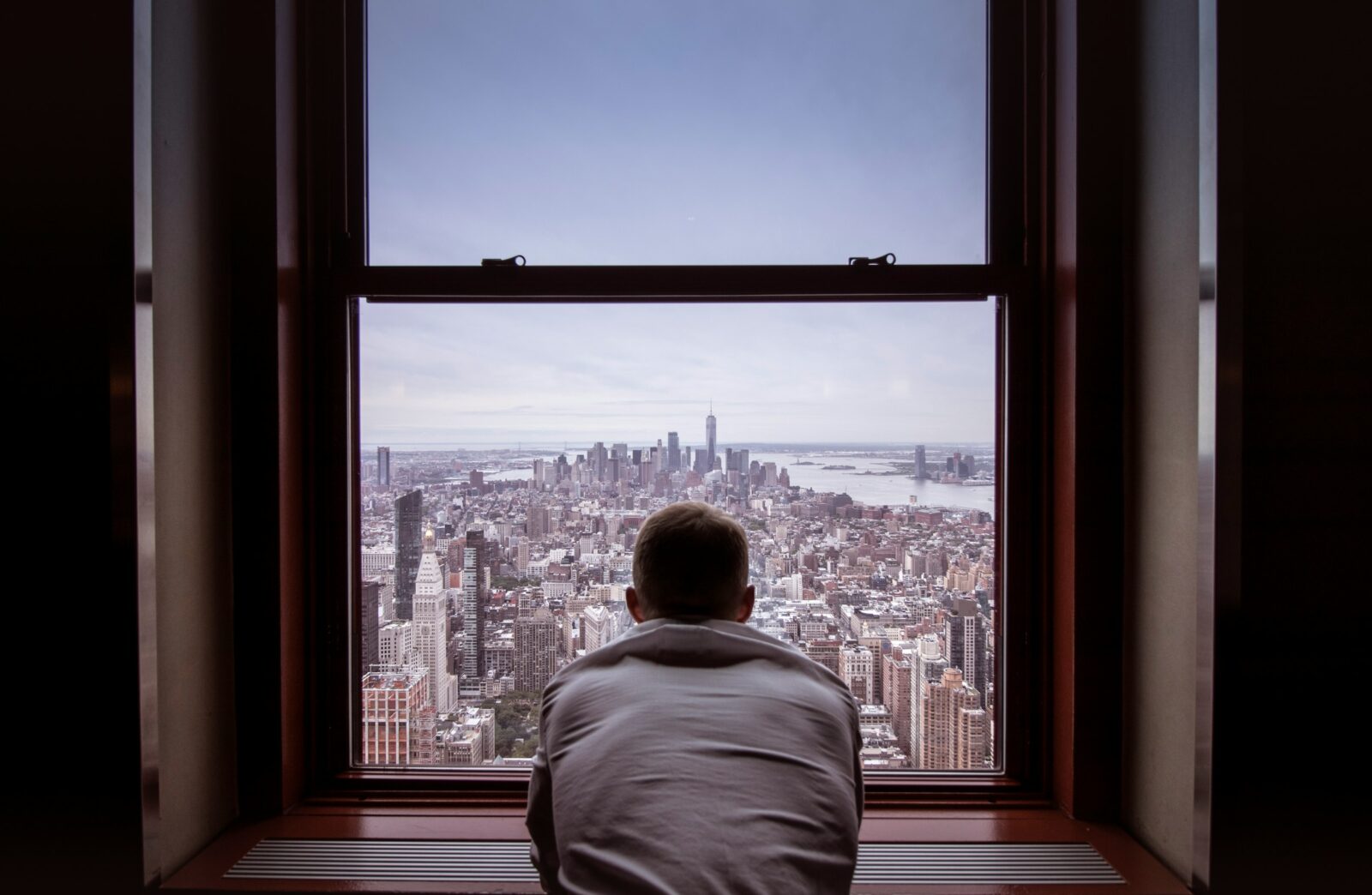 man in a gray shirt looking at city buildings during daytime