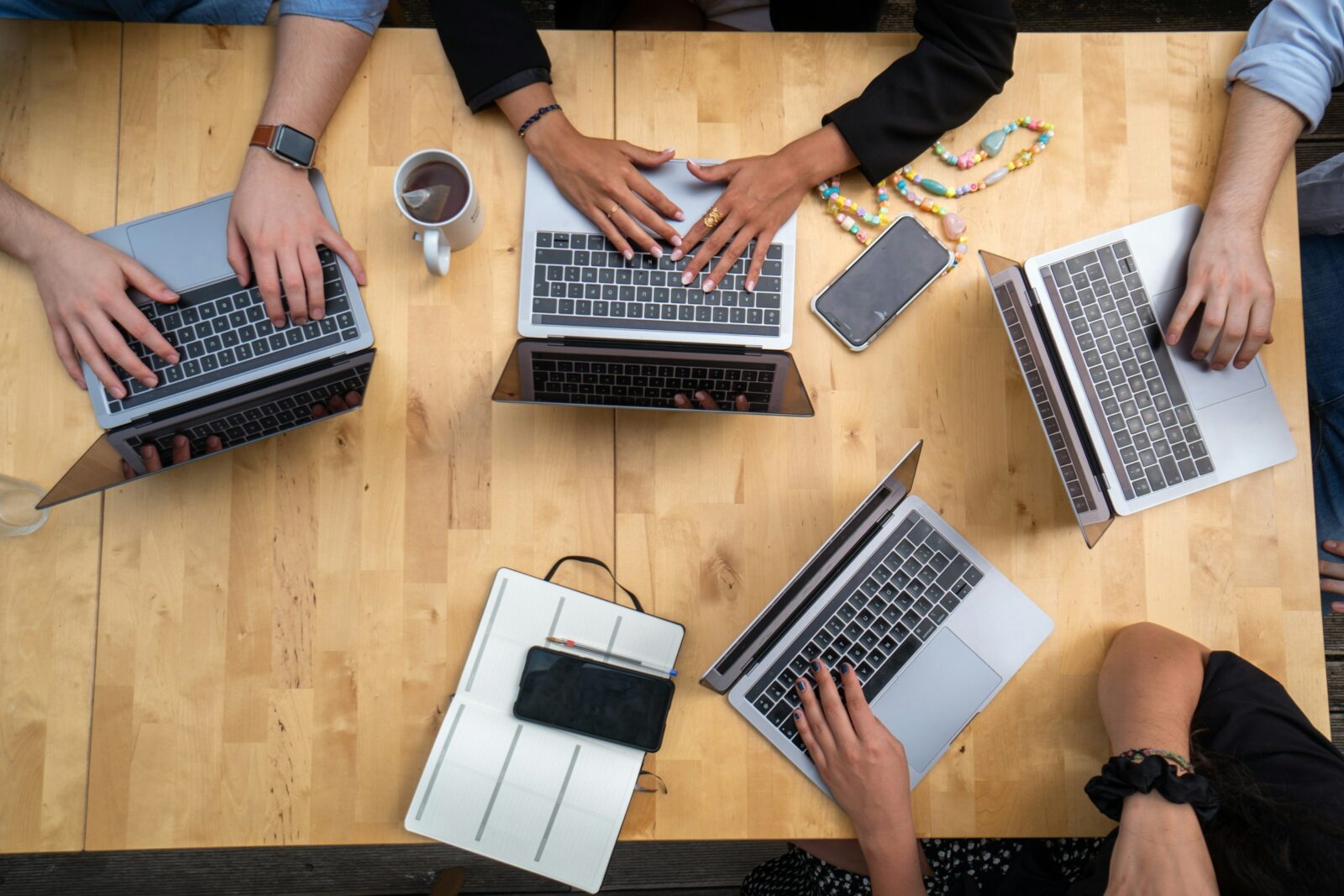 team working and using macbooks pro on brown wooden table