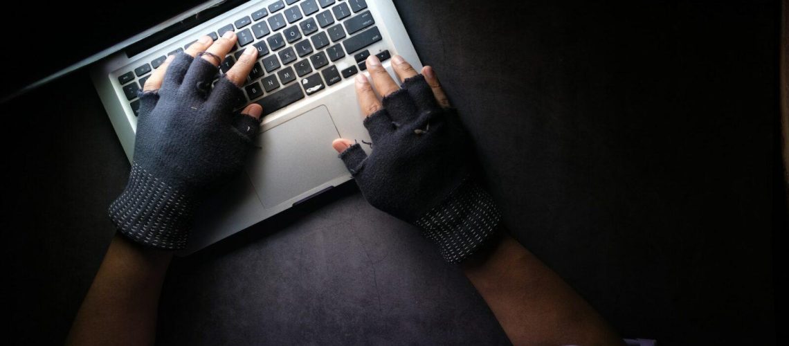 Hacker Hand Stealing Data From Laptop Top Down View