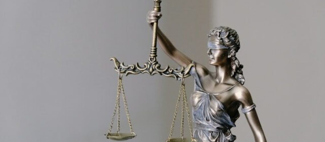 bronze statue lady of justice blindfolded with a scale representing the law